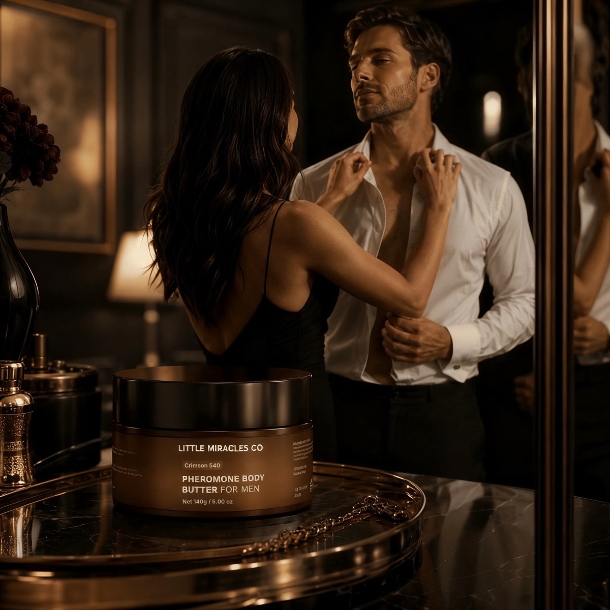 A jar of body butter on a gold tray as a couple gets ready in a warmly lit dressing room